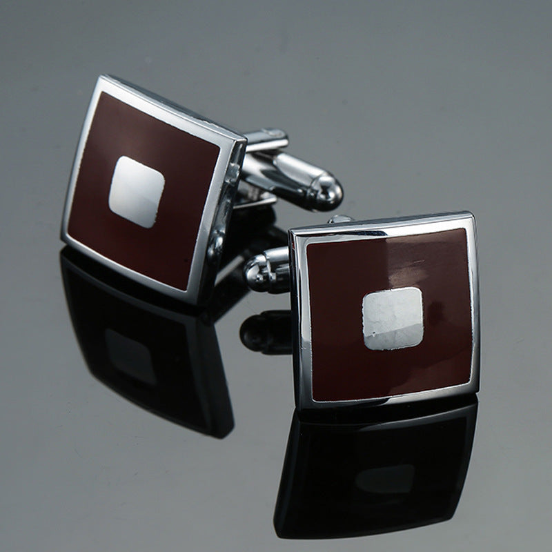 A pair of silver-tone cufflinks with a brown enamel square face and a central polished square detail