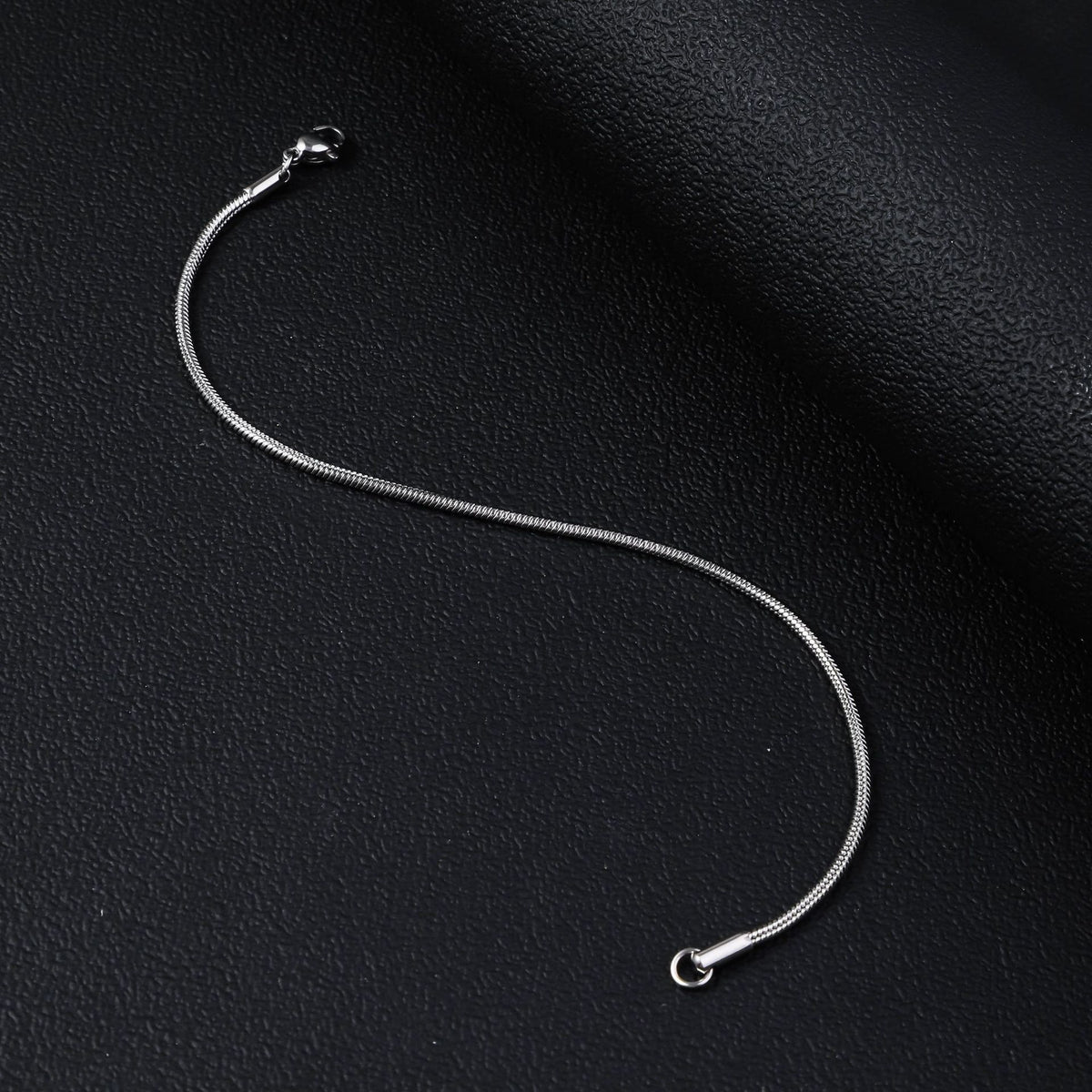 Silver-tone stainless steel round snake chain men's bracelet with a polished finish and lobster clasp