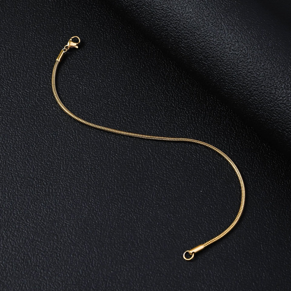 Gold-tone stainless steel snake chain bracelet with smooth weave and lobster clasp