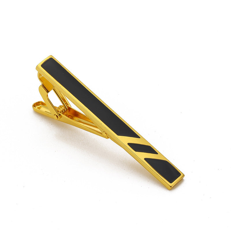Gold-tone metal tie clip with black enamel inlay and angled geometric stripes