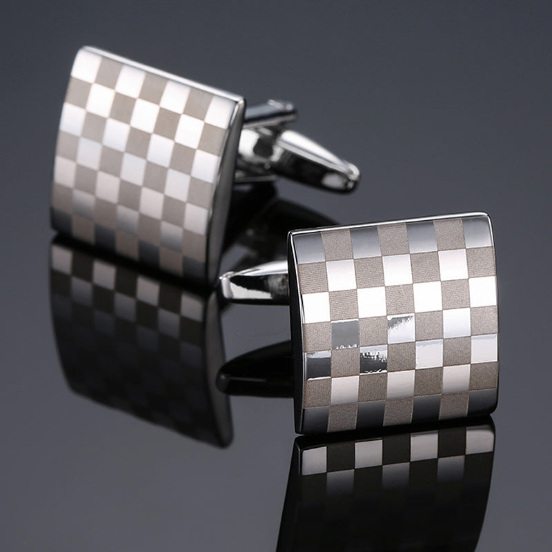 A pair of silver-tone cufflinks with a square checkerboard pattern of alternating brushed and polished finishes.