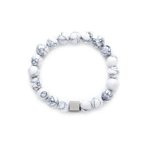 White marble-effect beaded bracelet with a central matte silver-tone cube bead on a white background