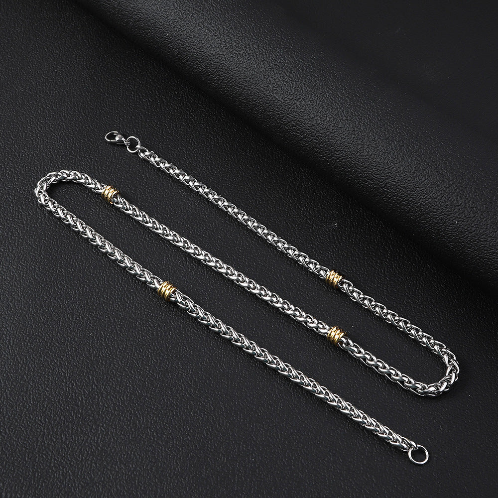 Silver-tone wheat chain necklace featuring alternating gold-tone steel ring accents and a round spring clasp.