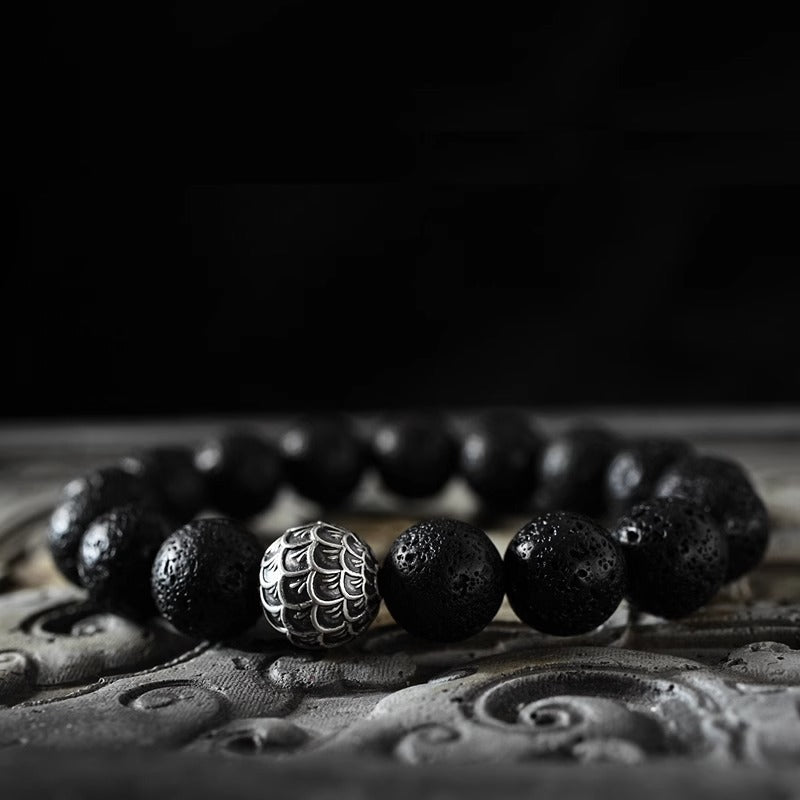 Men's lava stone bead bracelet featuring a scale-engraved silver-tone accent bead on a dark cord